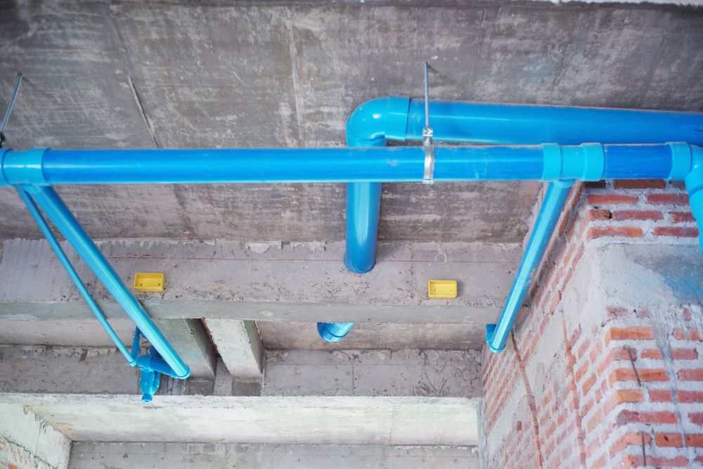 Blue PVC water pipes fixed under a concrete slab on a building site