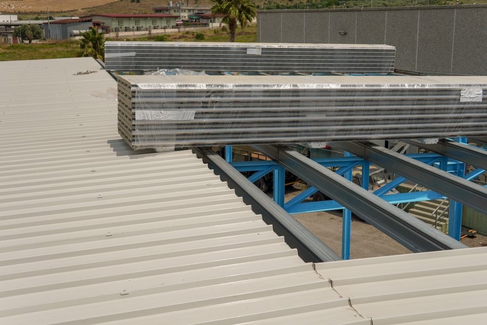 Stacks of roofing sheets placed on a commercial roof frame during installation