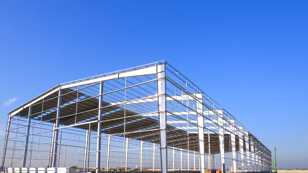 Steel frame of a large industrial building against a blue sky